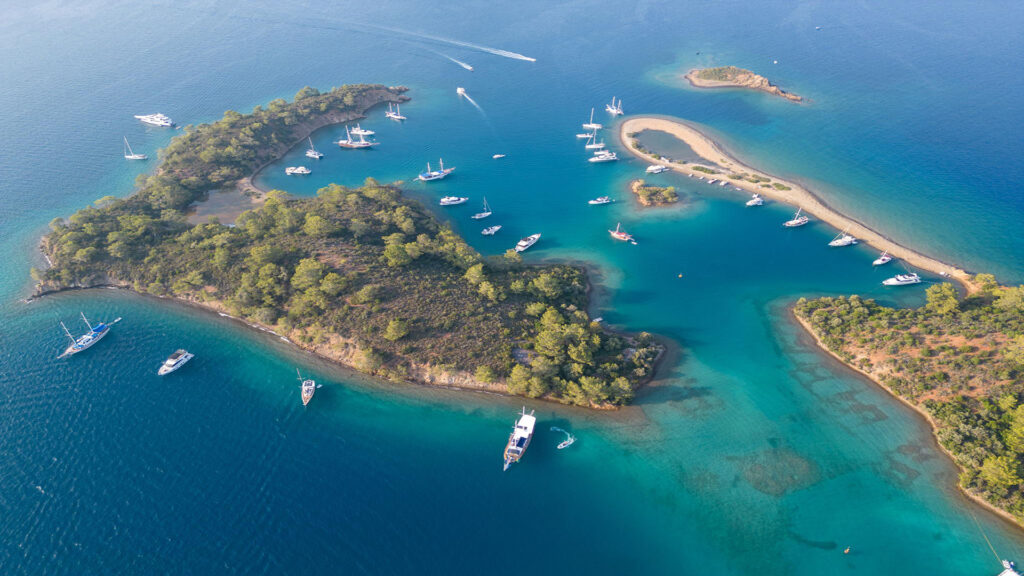 Aerial view of the Yassıca Islands near Göcek, with gulets anchored around a sandy spit
